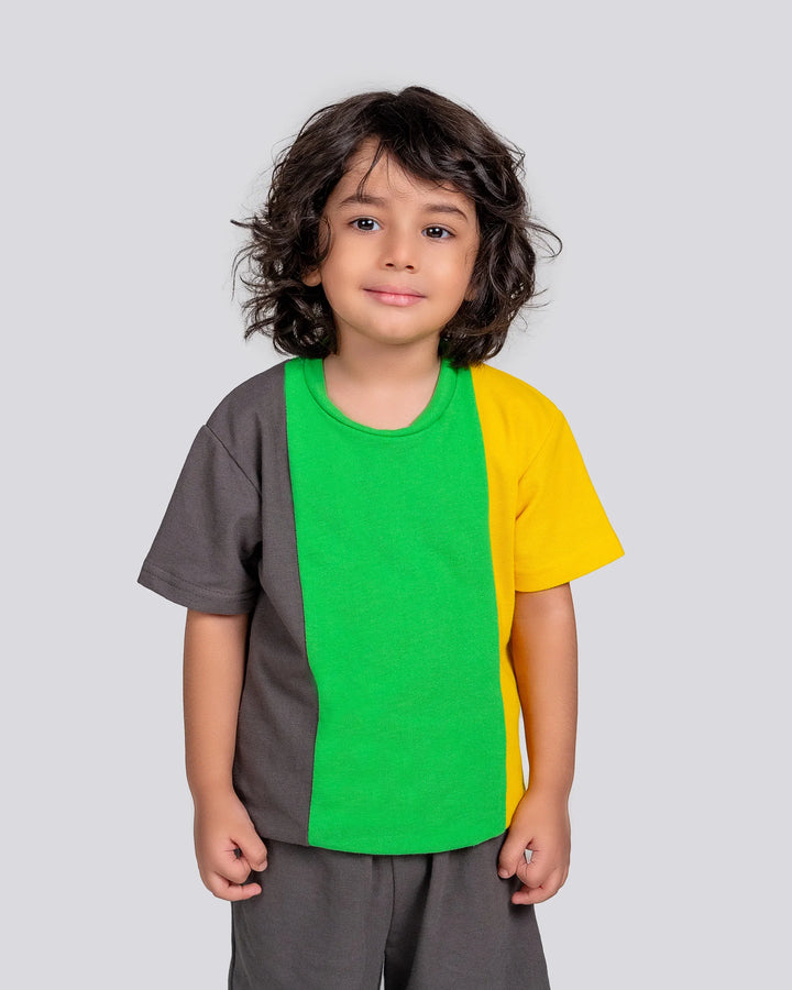 Child wearing a colorful shirt with gray, green, and yellow sections on a light gray background