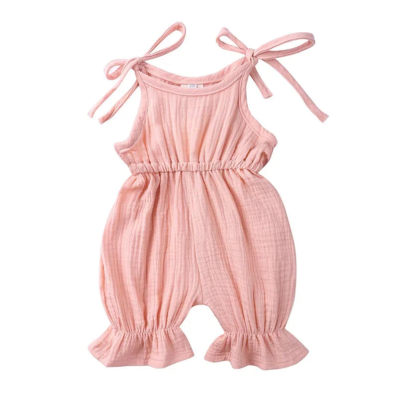 Pink baby romper with tie straps on a white background