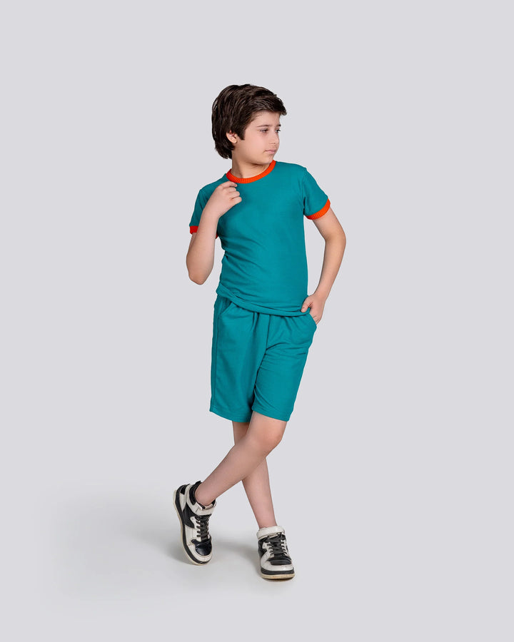 Child wearing a teal outfit with orange accents on a light gray background