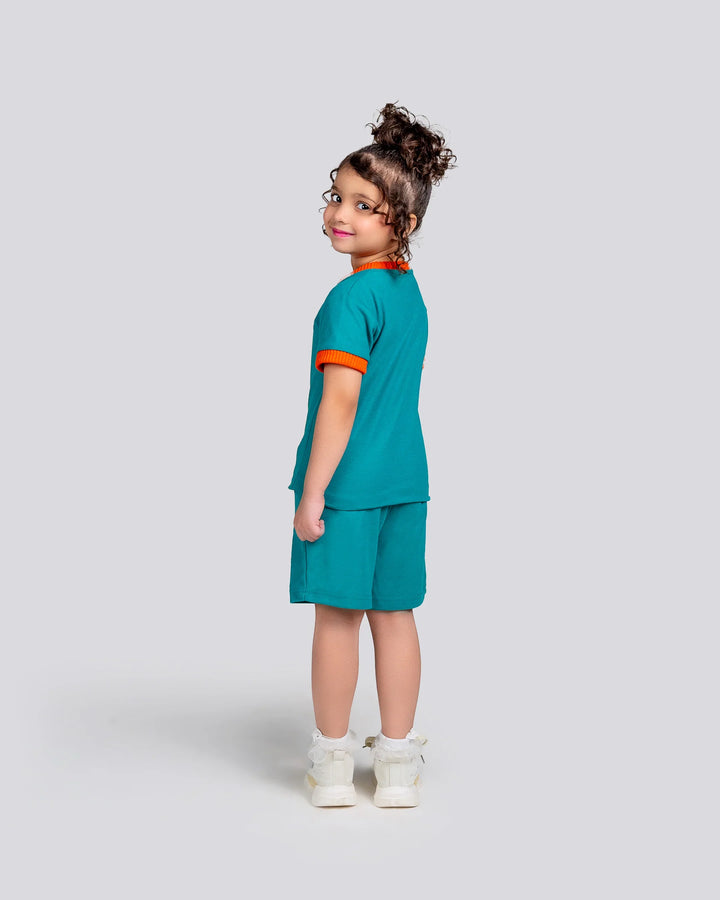 Child wearing a teal outfit with orange trim on a light gray background