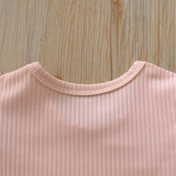 Close-up of a pink ribbed fabric collar on a wooden background