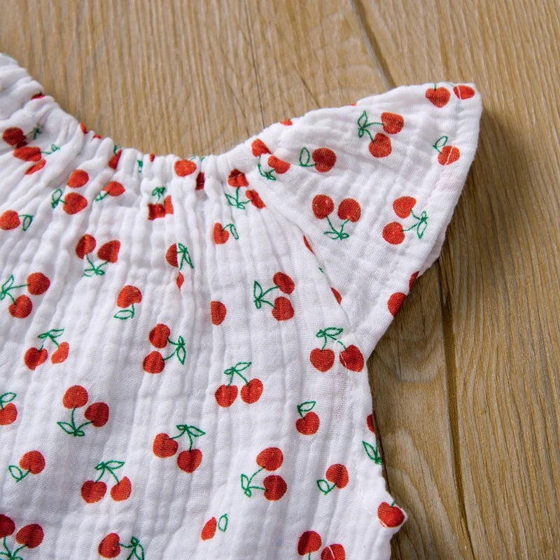White fabric with red cherry pattern on a wooden surface