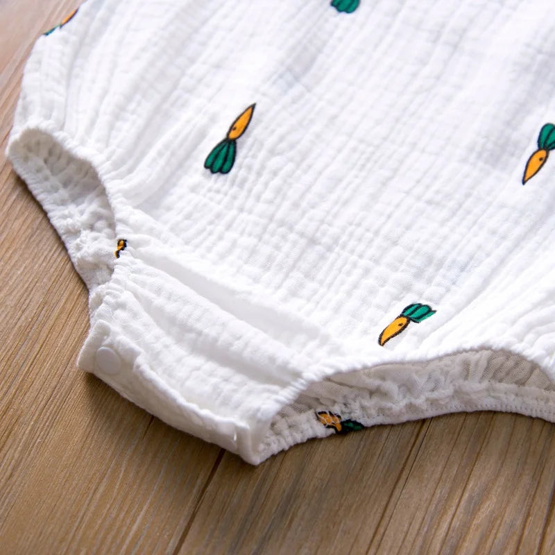 White textured fabric with embroidered carrot designs on a wooden surface