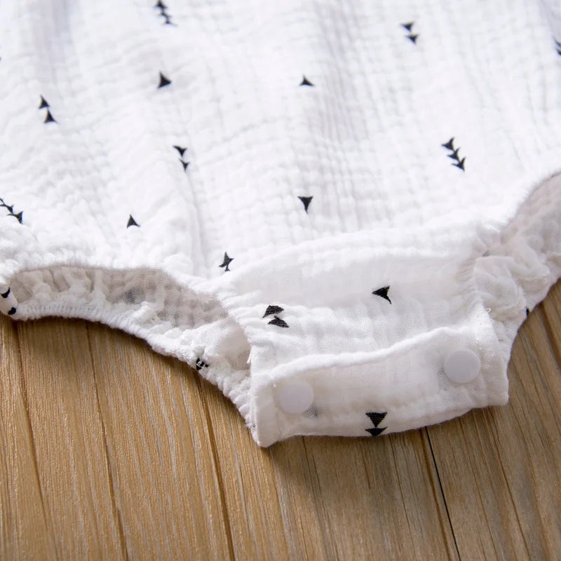 White baby blanket with black star pattern on a wooden surface