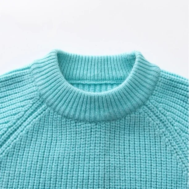 Close-up of a turquoise knitted sweater on a light gray background