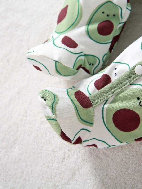 Pair of baby shoes with avocado pattern on a soft surface