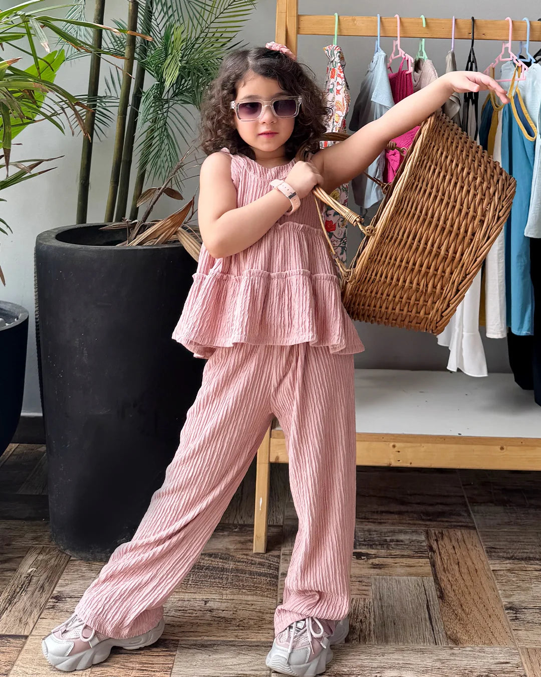 Child in pink outfit holding a basket in a store setting