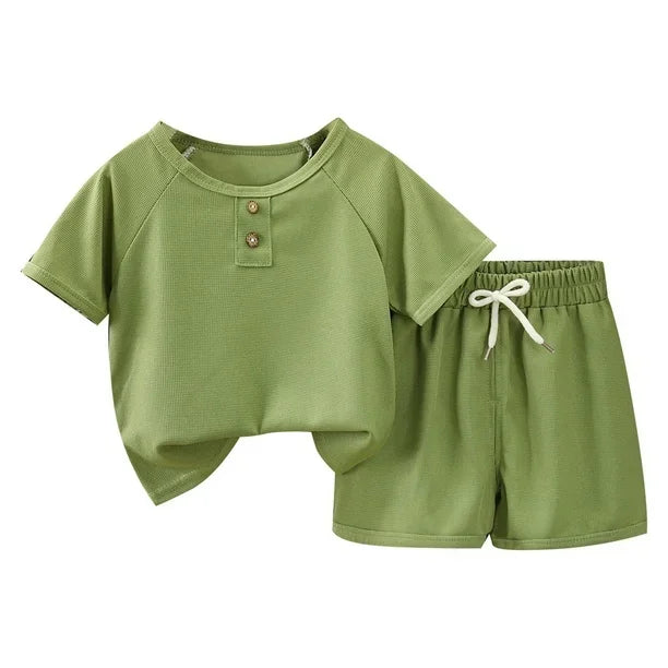 Green children's shirt and shorts set on a white background