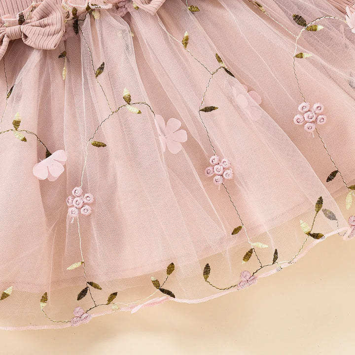 Pink tulle skirt with floral and butterfly embroidery on a beige background