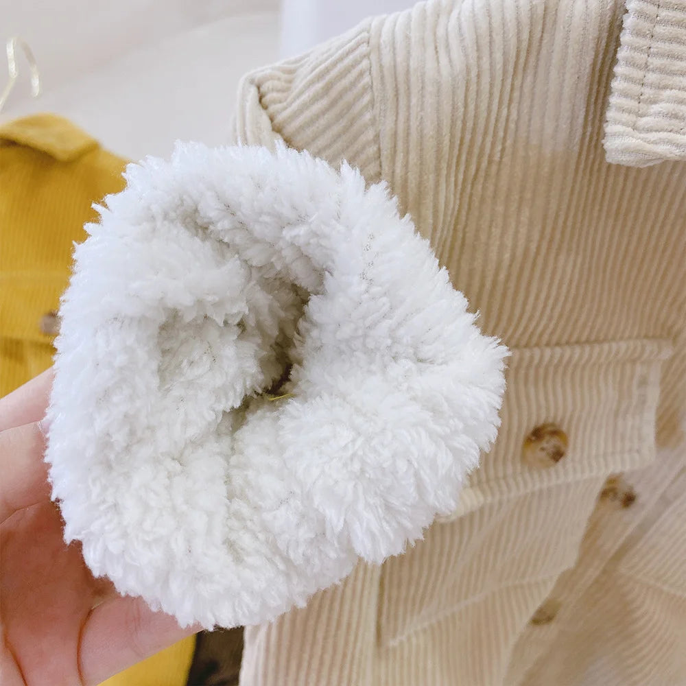 White fluffy scrunchie held in front of a beige textured fabric background