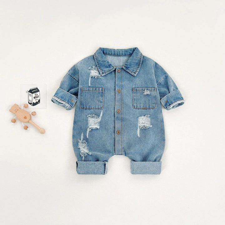Denim baby romper with distressed details on a white background