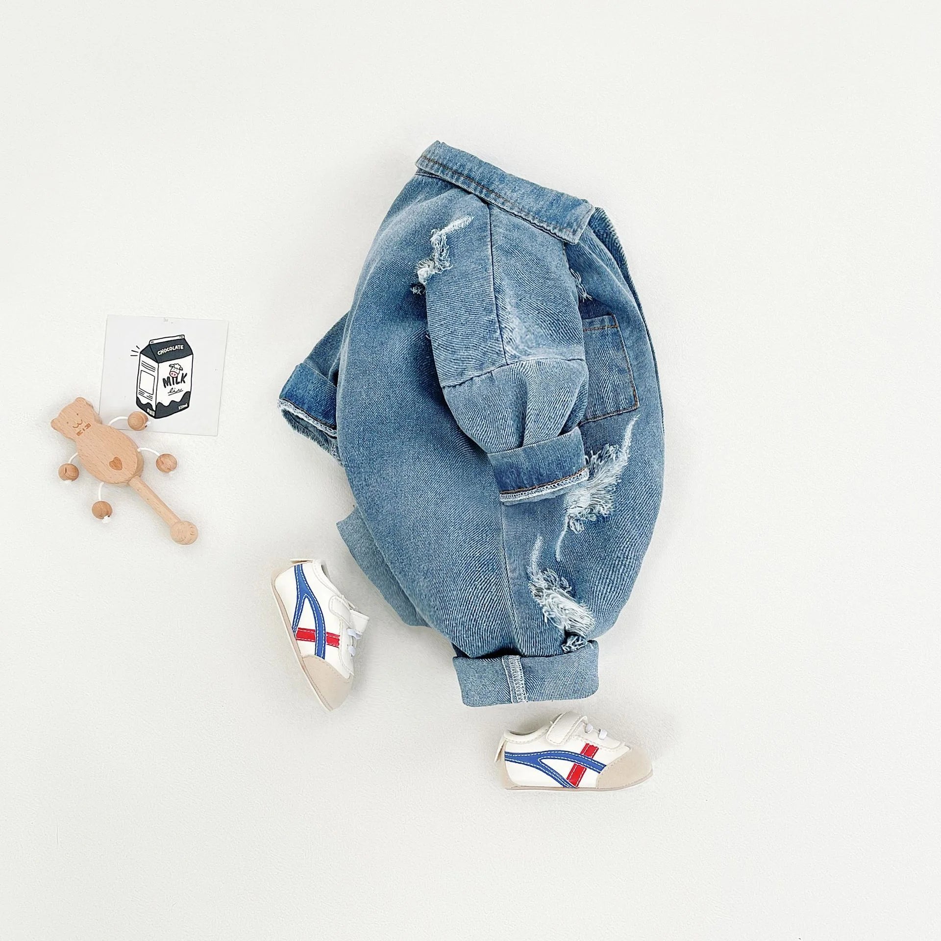 Children's denim jacket and shoes on a light gray background