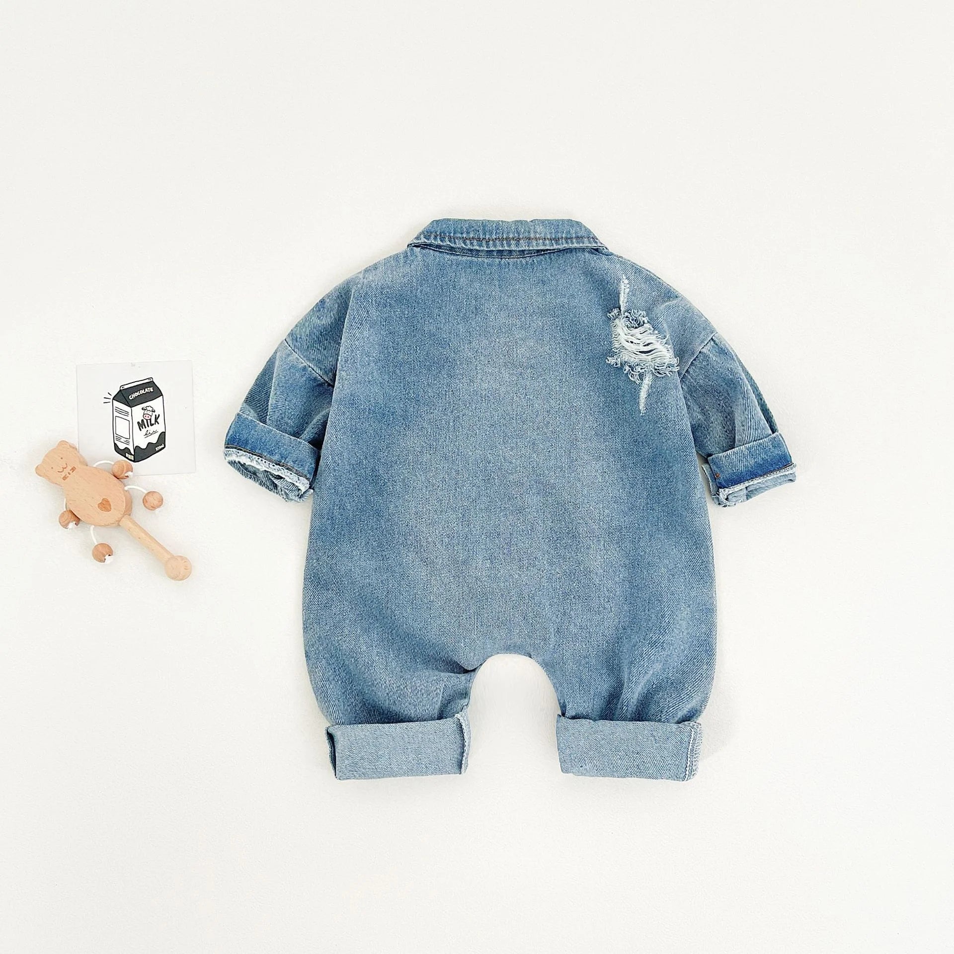 Blue denim baby romper on a mannequin with a white background