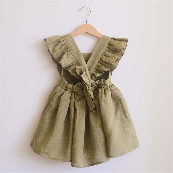 Green dress with ruffled straps on a hanger against a white background