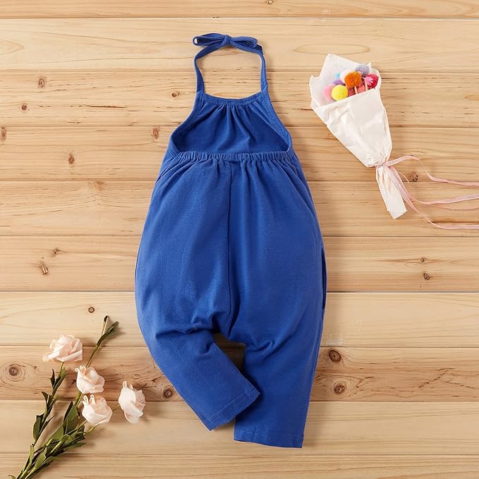 Blue children's romper on a wooden surface with flowers and a small bouquet.