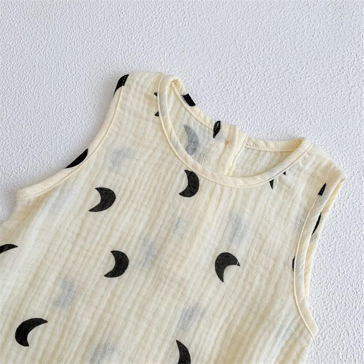 Beige sleeveless top with black crescent moon patterns on a white background