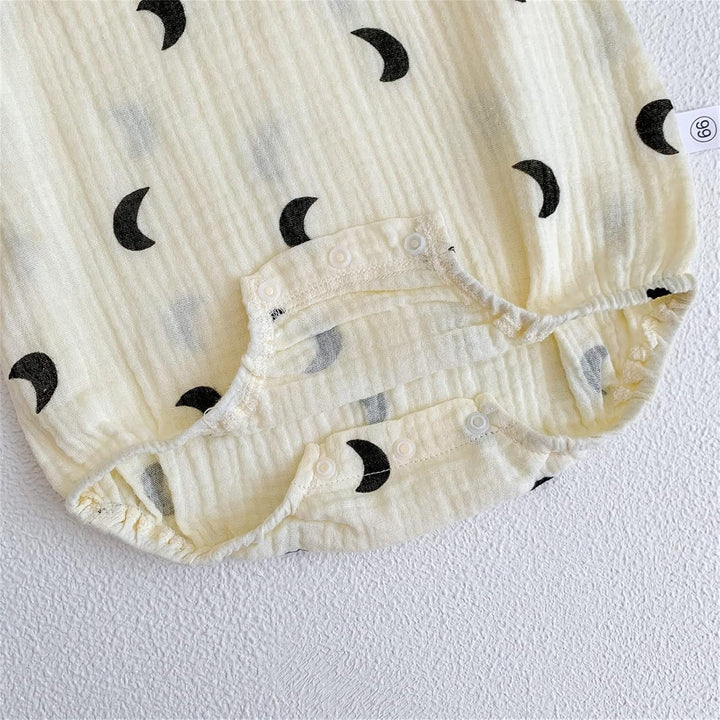 Baby onesie with black crescent moon patterns on a white background