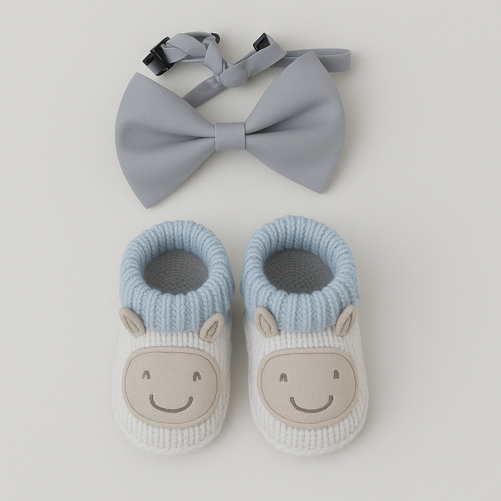 A set of baby booties with a sheep design and a gray contrast bow tie.