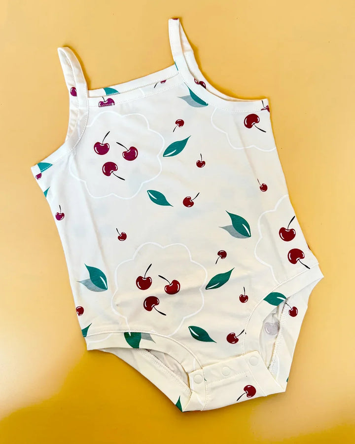 White tank top with cherry pattern on a yellow background