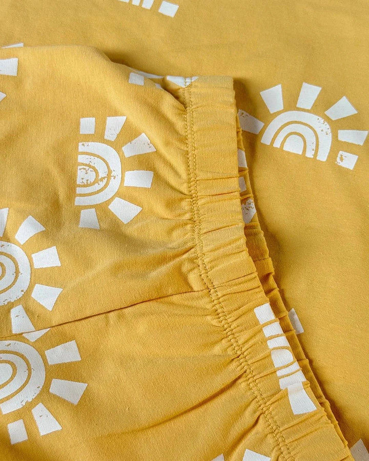 Yellow shorts with white sun patterns on a matching yellow background
