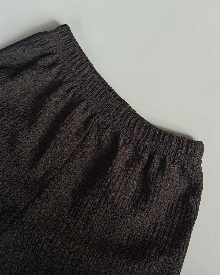 Dark brown pants on a light gray background