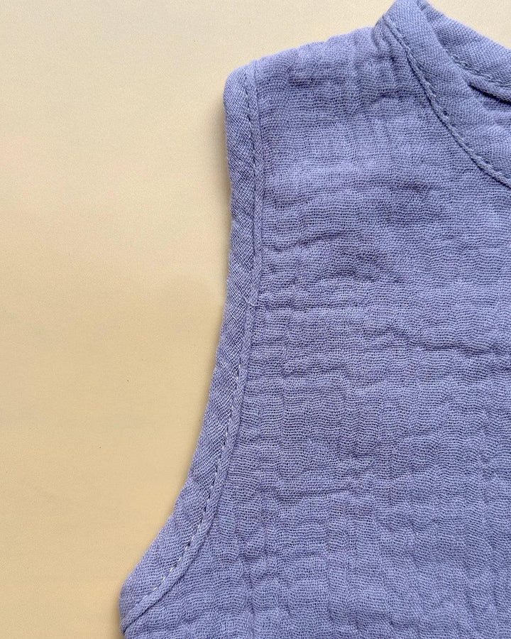 Close-up of a textured blue fabric sleeve on a beige background