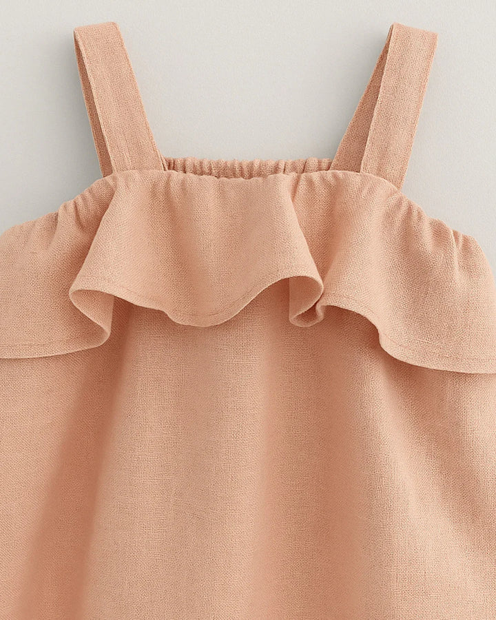 Pink ruffled top with straps on a light gray background