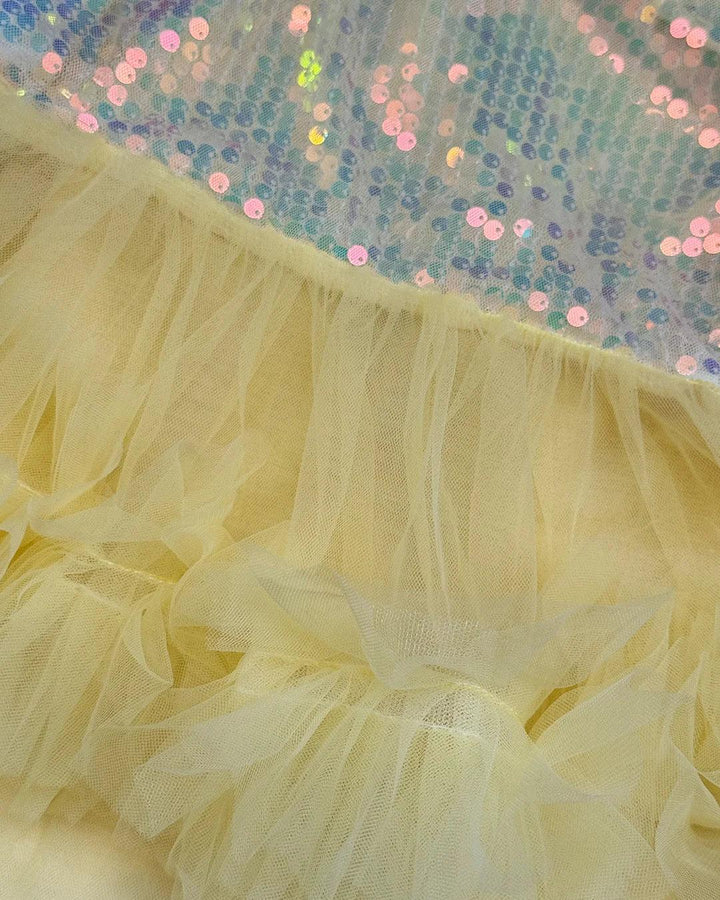 Close-up of a yellow tulle skirt with a sequined background.
