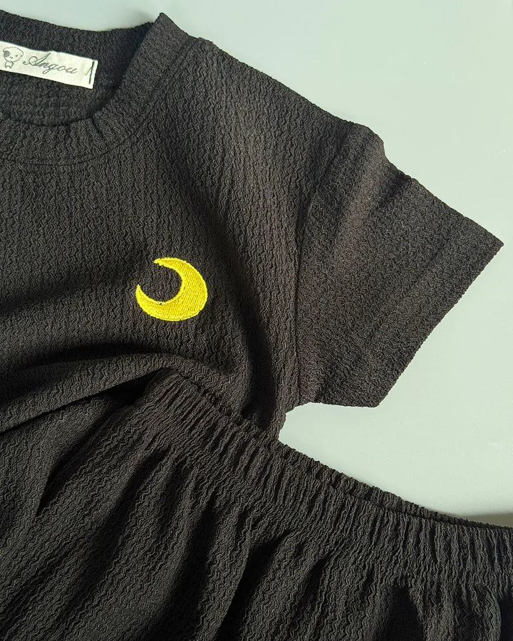 Dark gray dress with a yellow crescent moon design on a light green background