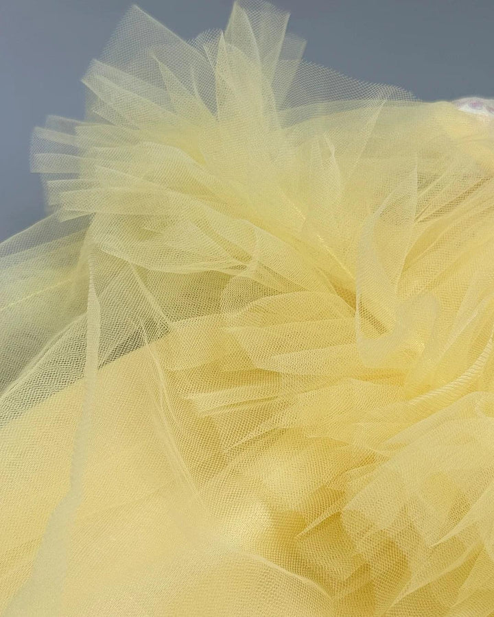 Close-up of yellow tulle fabric against a dark background