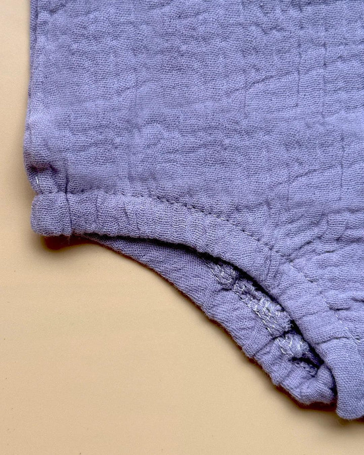 Close-up of a textured purple fabric on a beige background
