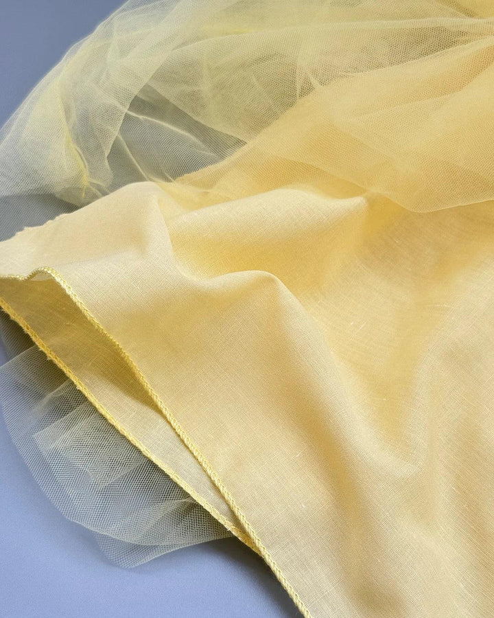 Close-up of yellow fabric with a soft texture on a light blue background