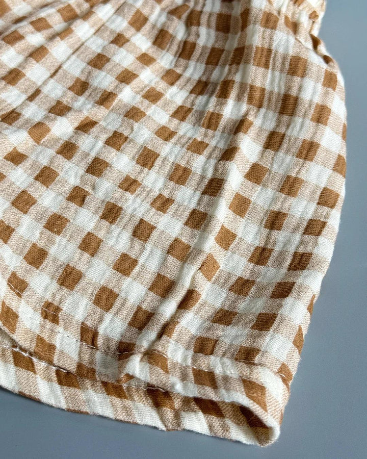 Folded brown and white checkered fabric on a gray background