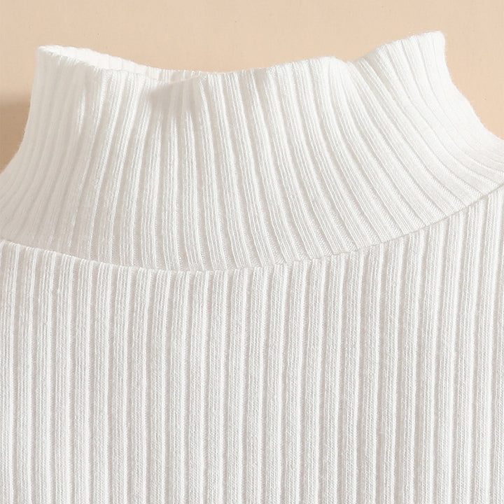 Close-up of a white ribbed knit top on a beige background