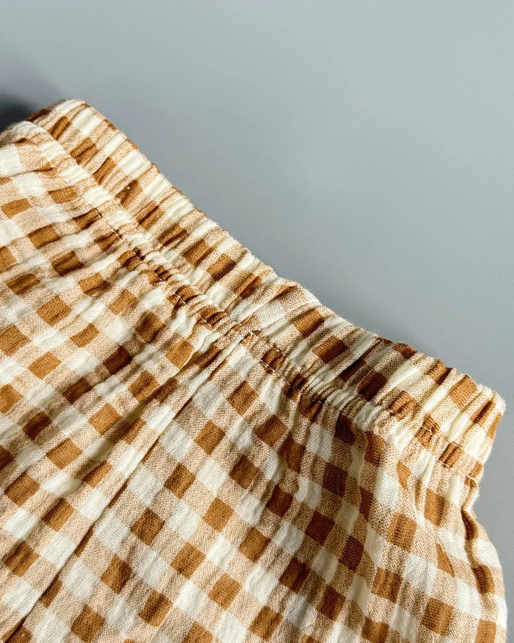 Close-up of a checkered fabric with brown and beige pattern on a gray background