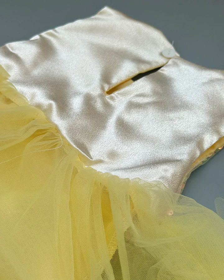 Close-up of a yellow fabric with a white satin backing on a gray background