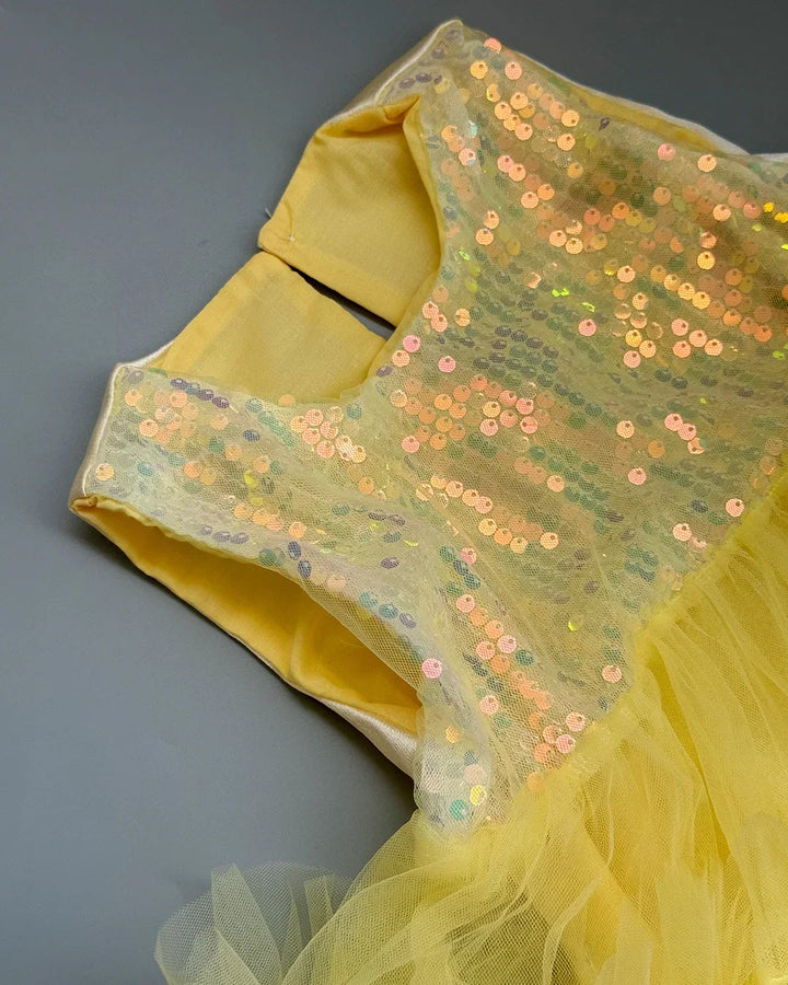 Yellow fabric with sequin detailing on a gray background
