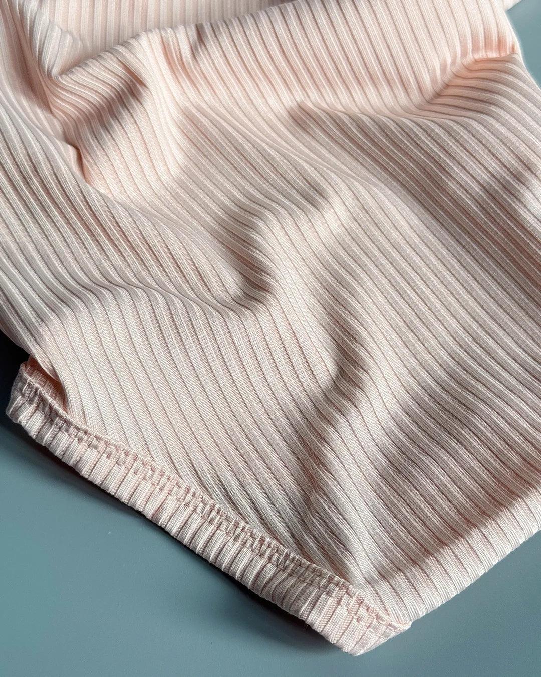 Close-up of ribbed pink shorts on a blue background