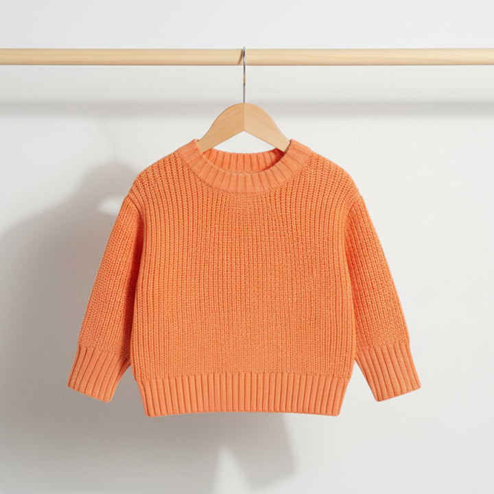 Orange sweater on a wooden hanger against a white background