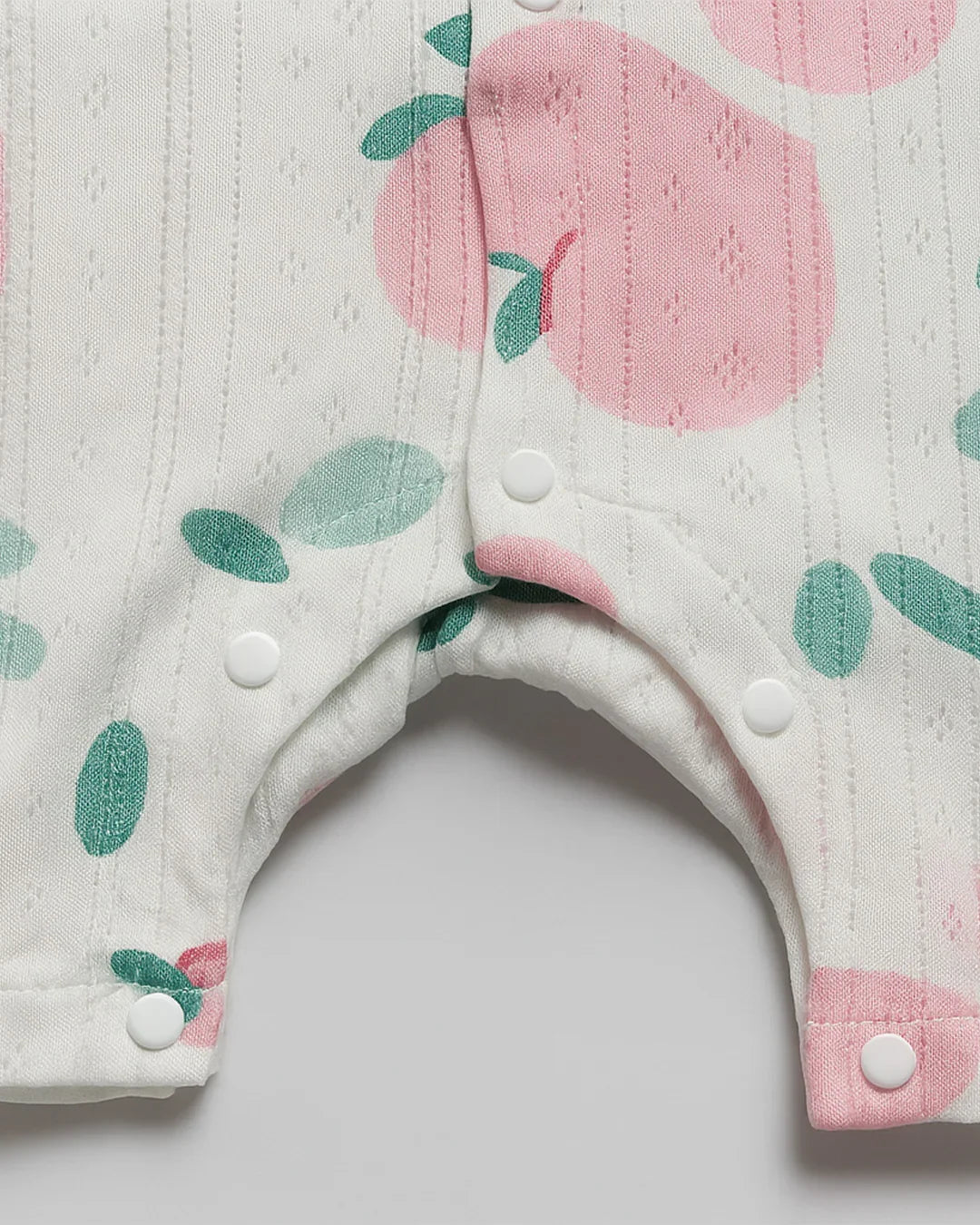 Baby bib with pink and green floral pattern on a white background