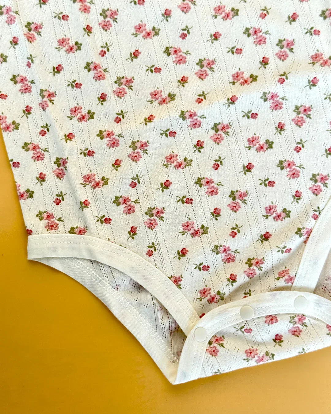 Floral-patterned fabric with pink flowers on a yellow background