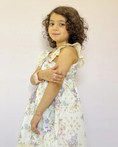 Young girl wearing a floral dress against a plain background