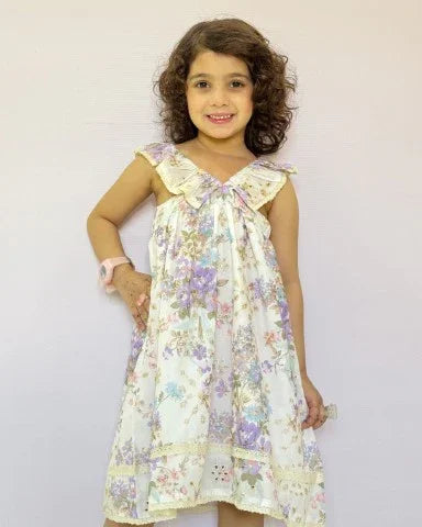 Young girl wearing a floral dress against a plain background
