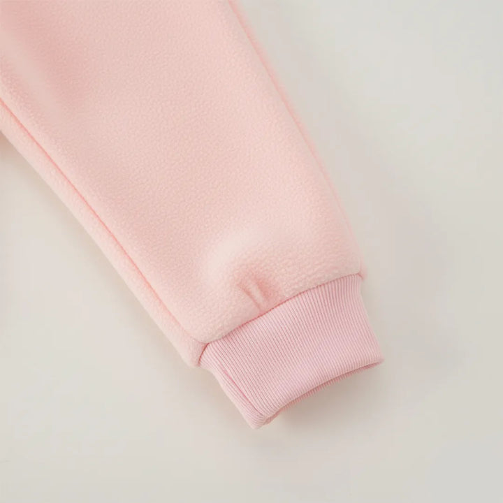 Close-up of a pink sweatshirt sleeve on a light gray background