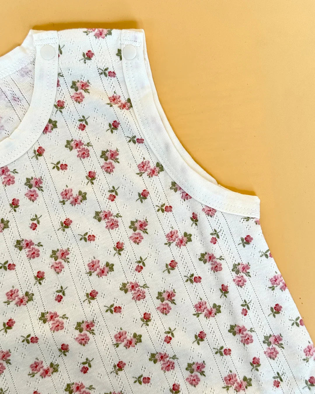 Floral-patterned sleeveless top on a beige background