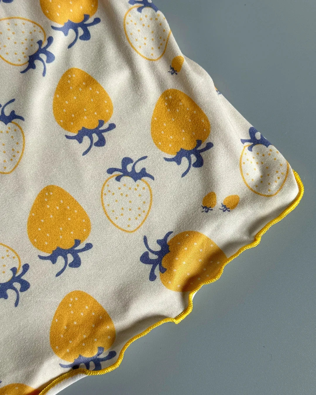 Fabric with yellow strawberry pattern on a gray background