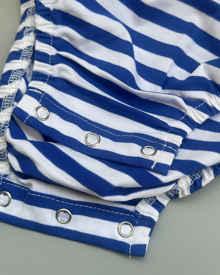 Close-up of blue and white striped fabric with grommets on a gray background