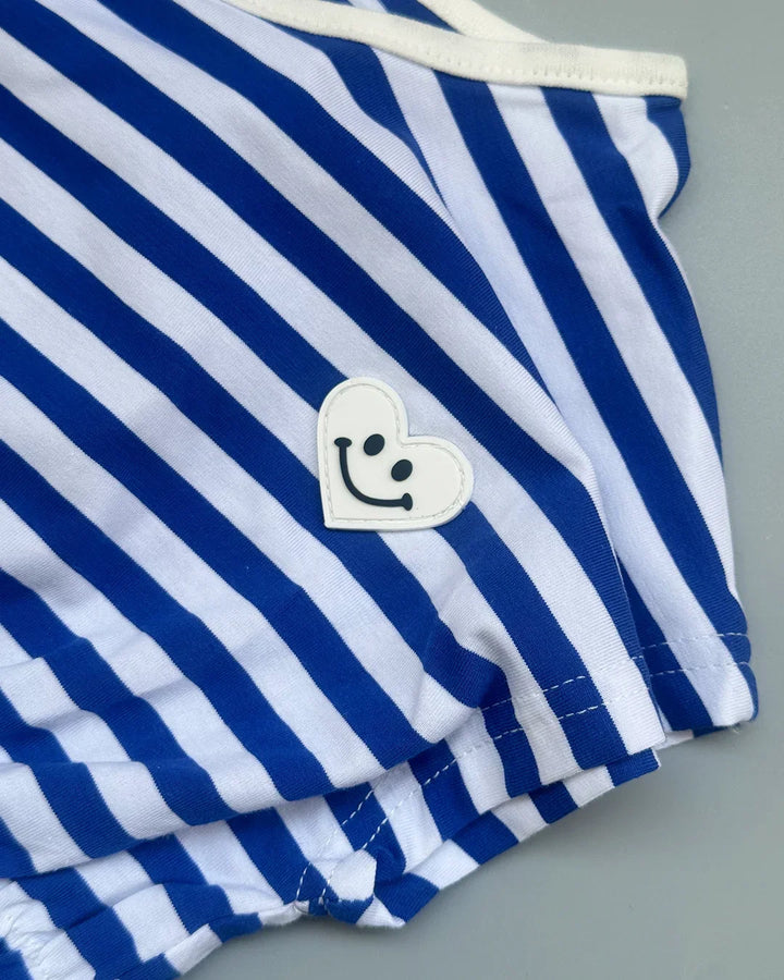 Blue and white striped garment with a smiley face patch on a gray background
