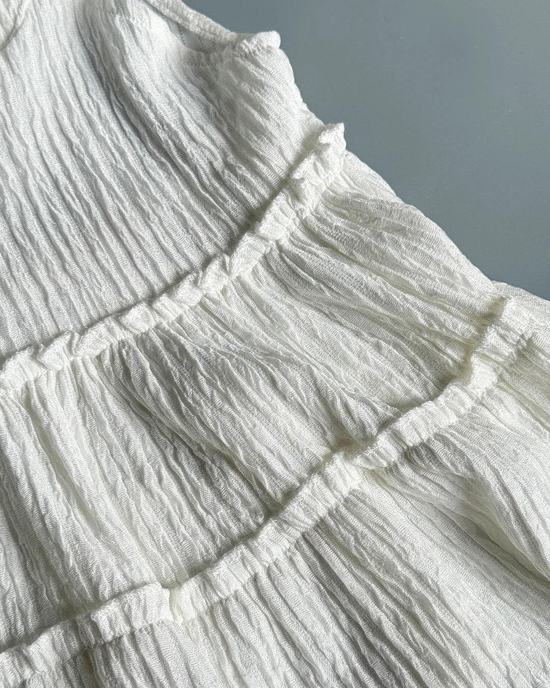 Close-up of textured white fabric with ruffled layers.