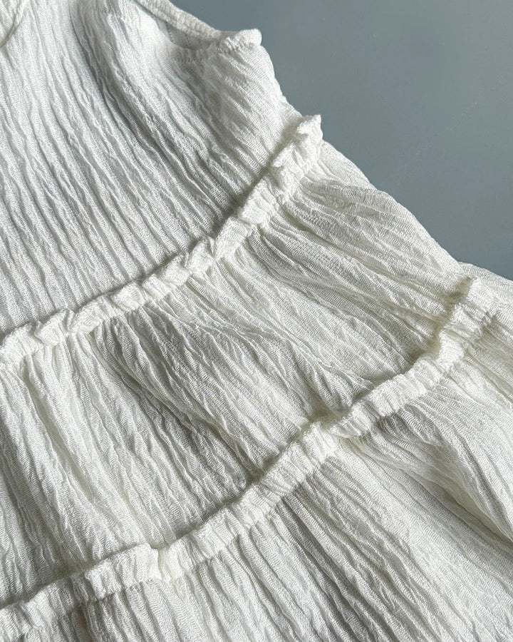 Close-up of textured white fabric with ruffled layers.